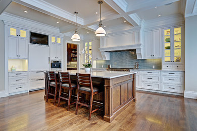 Example of a large transitional l-shaped medium tone wood floor eat-in kitchen design in Calgary with an undermount sink, shaker cabinets, white cabinets, marble countertops, gray backsplash and an island