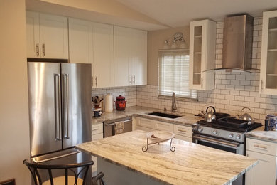 Mid-sized traditional l-shaped separate kitchen in Detroit with an undermount sink, shaker cabinets, white cabinets, granite benchtops, white splashback, subway tile splashback, stainless steel appliances, dark hardwood floors, with island and brown floor.