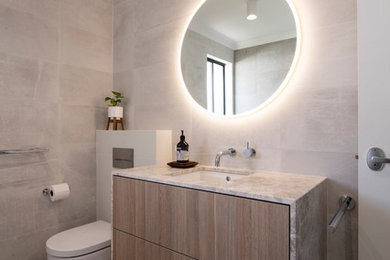 Inspiration for a small contemporary 3/4 bathroom in Perth with furniture-like cabinets, light wood cabinets, an open shower, a wall-mount toilet, porcelain tile, porcelain floors, an undermount sink, marble benchtops, grey benchtops, a corner tub, beige tile, beige walls, beige floor and a hinged shower door.