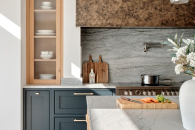 Photo of a modern kitchen pantry in Hertfordshire with shaker cabinets, porcelain flooring, an island, beige floors and feature lighting.