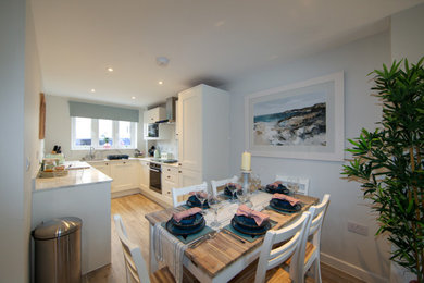 Photo of a medium sized open plan dining room in Dorset with white walls and light hardwood flooring.
