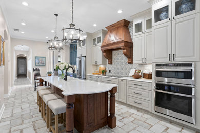 Eat-in kitchen - mid-sized contemporary l-shaped eat-in kitchen idea in Tampa with an undermount sink, shaker cabinets, white cabinets, quartz countertops, white backsplash, mosaic tile backsplash, stainless steel appliances, an island and white countertops