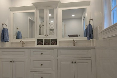 Mid-sized elegant master white tile and porcelain tile porcelain tile and gray floor doorless shower photo in Other with furniture-like cabinets, white cabinets, a one-piece toilet, gray walls, an undermount sink, quartz countertops and a hinged shower door