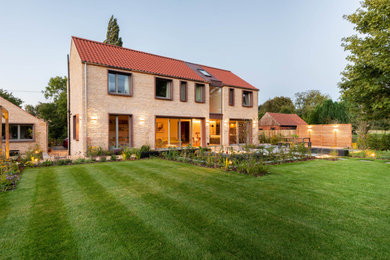 Diseño de fachada de casa beige y roja contemporánea de tamaño medio de dos plantas con revestimiento de piedra, tejado a dos aguas y tejado de teja de barro