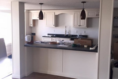 Example of a mid-sized kitchen design in Chicago with white cabinets and no island