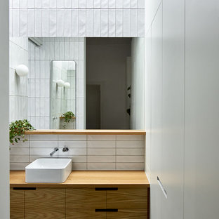 Photo of a small contemporary master bathroom in Melbourne with flat-panel cabinets, light wood cabinets, white tile, ceramic tile, white walls, porcelain floors, a vessel sink, wood benchtops, grey floor and brown benchtops.