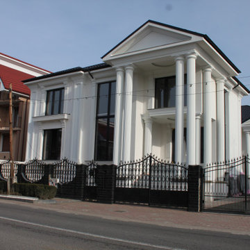 House with portico and wrought-iron fence, seen from the street