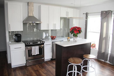 Inspiration for a mid-sized transitional medium tone wood floor and brown floor kitchen remodel in San Diego with an undermount sink, shaker cabinets, white cabinets, quartzite countertops, gray backsplash, ceramic backsplash, stainless steel appliances and an island