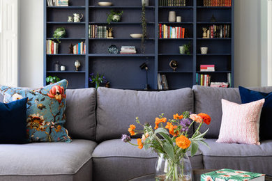 Living room library - traditional living room library idea in Surrey with gray walls