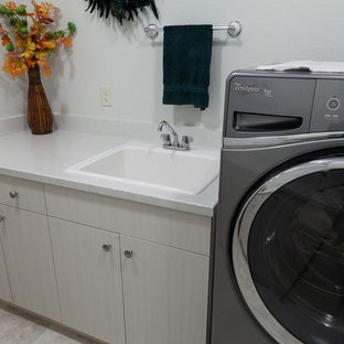 他の地域の中サイズのコンテンポラリースタイルのおしゃれな洗濯室 (ドロップインシンク、白い壁、セラミックタイルの床、ベージュの床、フラットパネル扉のキャビネット、淡色木目調キャビネット、テラゾーカウンター、左右配置の洗濯機・乾燥機) の写真