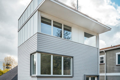 Photo of a contemporary three-storey brown house exterior in Seattle with concrete fiberboard siding and a flat roof.