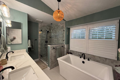 Example of a large transitional master green tile and porcelain tile porcelain tile, beige floor, double-sink, vaulted ceiling and wainscoting bathroom design in Baltimore with flat-panel cabinets, brown cabinets, a two-piece toilet, green walls, an undermount sink, quartz countertops, a hinged shower door, white countertops, a niche and a built-in vanity