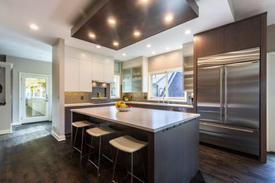 Photo of a mid-sized contemporary l-shaped eat-in kitchen in Minneapolis with an undermount sink, flat-panel cabinets, dark wood cabinets, quartz benchtops, beige splashback, porcelain splashback, stainless steel appliances, dark hardwood floors, with island, brown floor and white benchtop.