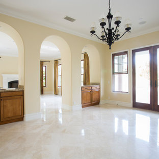 Mittelgroßes, Repräsentatives, Fernseherloses, Abgetrenntes Mediterranes Wohnzimmer ohne Kamin mit gelber Wandfarbe, Porzellan-Bodenfliesen und gelbem Boden in Orange County