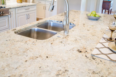 Kitchen photo in Other with granite countertops, stainless steel appliances and an island