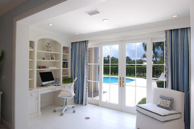 Home office - traditional built-in desk white floor home office idea in Miami with white walls