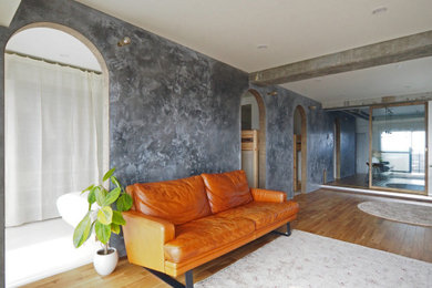 Ejemplo de salón abierto moderno pequeño sin chimenea con paredes grises, suelo de madera en tonos medios, televisor colgado en la pared, suelo marrón y papel pintado