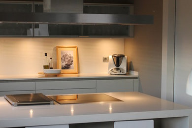 Photo of a large contemporary enclosed kitchen in Other with a double-bowl sink, flat-panel cabinets, white cabinets, engineered stone countertops, white splashback, cement tile splashback, integrated appliances, dark hardwood flooring and an island.