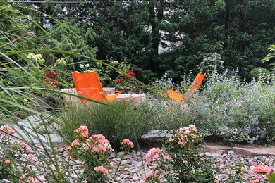 Inspiration for a mid-sized transitional backyard full sun xeriscape for summer in DC Metro with a fire feature and gravel.