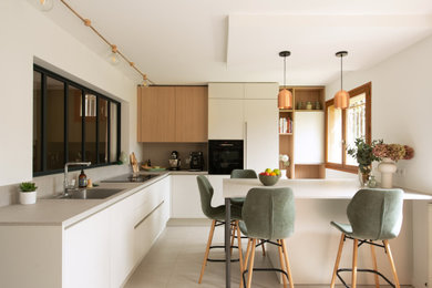 Idée de décoration pour une grande cuisine encastrable et blanche et bois minimaliste en L avec îlot, un sol beige et un plan de travail gris.