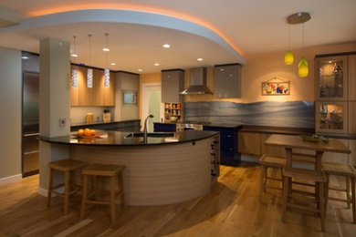 Example of a large trendy u-shaped light wood floor eat-in kitchen design in Portland with an undermount sink, flat-panel cabinets, light wood cabinets, granite countertops, multicolored backsplash, stone slab backsplash, stainless steel appliances and an island