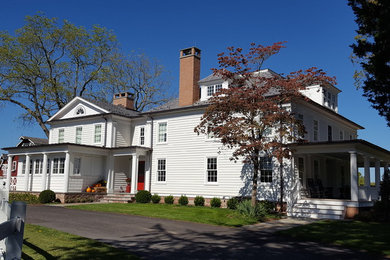 Photo of a traditional two-storey white exterior in New York with wood siding and a gable roof.