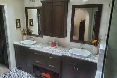 Inspiration for a large arts and crafts master bathroom in Phoenix with shaker cabinets, dark wood cabinets, an open shower, a one-piece toilet, white tile, ceramic tile, white walls, porcelain floors, a vessel sink, granite benchtops, grey benchtops, a double vanity and a built-in vanity.