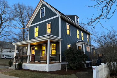 Ejemplo de fachada de casa gris y negra tradicional renovada de tamaño medio de tres plantas con revestimiento de aglomerado de cemento, tejado a dos aguas, tejado de teja de madera y tablilla