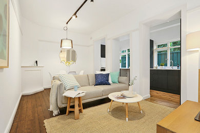 Photo of a small modern open concept living room in Sydney with white walls and dark hardwood floors.