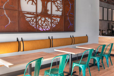 Example of a mid-sized urban light wood floor and wallpaper ceiling dining room design in Chicago