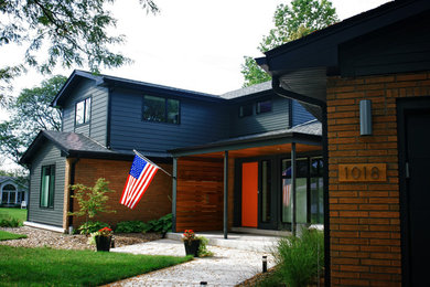 Design ideas for a mid-sized midcentury two-storey blue exterior in Chicago with mixed siding and a gable roof.