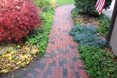Photo of a mid-sized traditional partial sun side yard brick landscaping in Boston for spring.