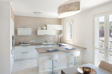 Foto di una piccola cucina contemporanea con lavello a doppia vasca, ante lisce, ante in legno chiaro, top in laminato, paraspruzzi a effetto metallico, elettrodomestici bianchi, pavimento in gres porcellanato e pavimento beige