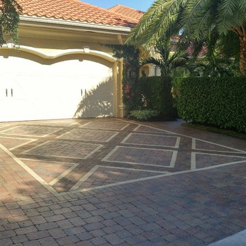 Lush colorful vines, hedges and elegant driveway paver design set the tone