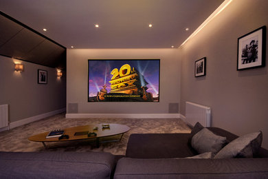 Diseño de cine en casa cerrado moderno de tamaño medio con paredes beige, moqueta, pantalla de proyección y suelo gris