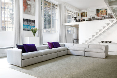 This is an example of a large contemporary living room in Milan with white walls.