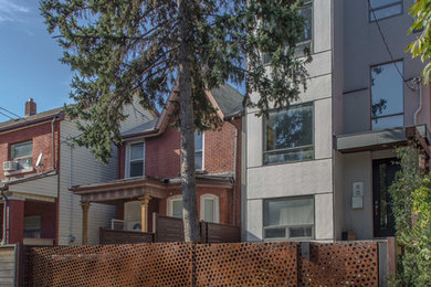 Example of a mid-sized transitional gray three-story vinyl flat roof design in Toronto
