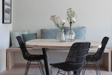 Ispirazione per una sala da pranzo aperta verso il soggiorno minimal di medie dimensioni con pareti bianche, parquet chiaro e pavimento turchese