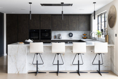 Moody open-plan kitchen with dark units and marble island
