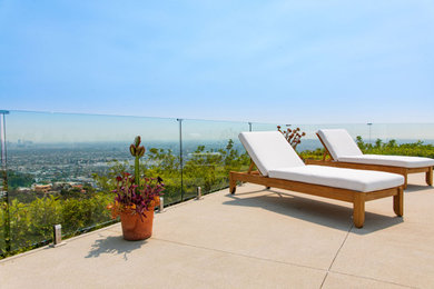 Inspiration for a mid-sized contemporary backyard ground level glass railing deck remodel in Los Angeles