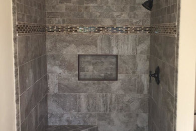Brown tile and ceramic tile ceramic tile bathroom photo in New York with beige walls and a hinged shower door
