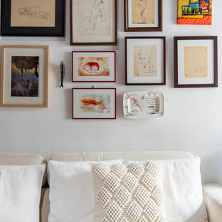 Imagen de salón para visitas tipo loft, mediterráneo, de tamaño medio, sin chimenea, con paredes blancas y televisor colgado en la pared