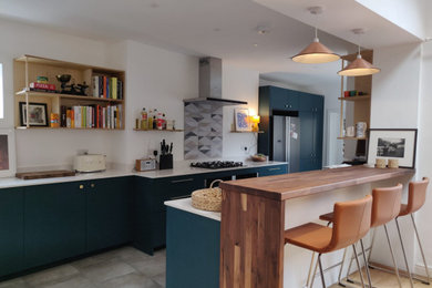 Inspiration for a mid-sized eclectic galley open concept kitchen remodel in London with flat-panel cabinets, green cabinets, quartzite countertops, multicolored backsplash, ceramic backsplash and white countertops
