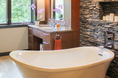 Large transitional master beige tile and porcelain tile pebble tile floor bathroom photo in Cedar Rapids with medium tone wood cabinets, beige walls, flat-panel cabinets and granite countertops