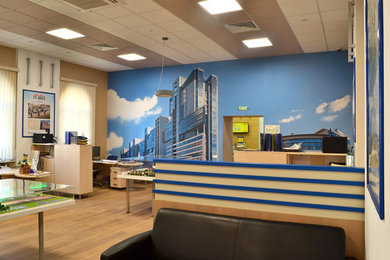 Стильный дизайн: большое рабочее место в современном стиле с синими стенами, полом из ламината, отдельно стоящим рабочим столом и коричневым полом - последний тренд