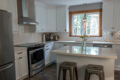 Mid-sized country l-shaped eat-in kitchen in Toronto with a double-bowl sink, recessed-panel cabinets, white cabinets, quartz benchtops, white splashback, ceramic splashback, stainless steel appliances, travertine floors, with island, grey floor and beige benchtop.