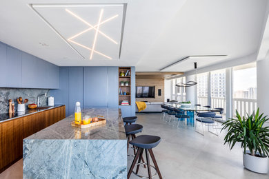 Modern l-shaped eat-in kitchen in Miami with an undermount sink, grey cabinets, quartzite benchtops, grey splashback, stone slab splashback, stainless steel appliances, porcelain floors, with island, grey floor and grey benchtop.