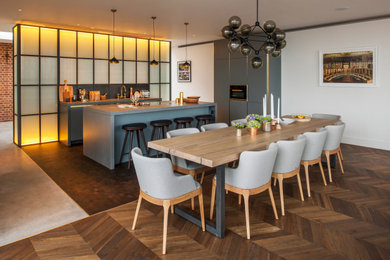 Medium sized contemporary open plan kitchen in London with medium hardwood flooring.