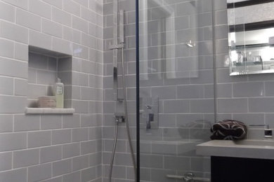 Inspiration for a small modern master gray tile and subway tile marble floor doorless shower remodel in New York with an integrated sink, flat-panel cabinets, black cabinets, concrete countertops, a one-piece toilet and gray walls