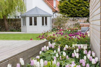 Medium sized classic back full sun garden for summer in Edinburgh with natural stone paving.